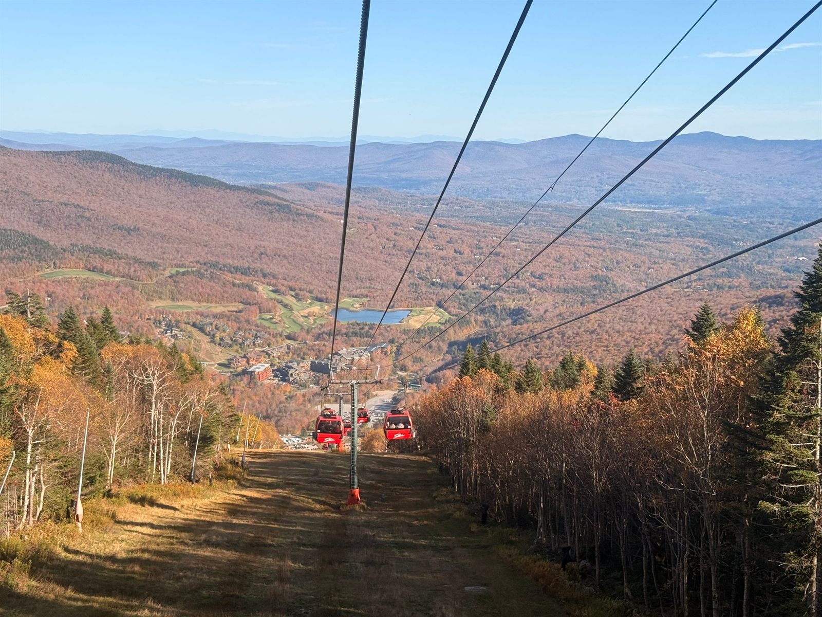 Ski-lift line running down a hillside of red and gold autumn trees in New England